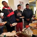 From left: Joseph Valbrun, 16; Chris Owens, 16; Leo Johnson, 14; and Osa Iyekekpolor, 17, lined up for seconds from teen coordinator DeLinda Sales during a holiday luncheon at the Dorchester YMCA last month.