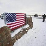 A US flag covered a sign at the entrance of the Malheur National Wildlife Refuge near Burns, Ore. 
