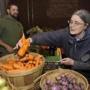 Customer Mary Talbot picked some fresh carrots as 4 Nichols watched at the Mill City Grows farmers market booth in Lowell. Mill City Grows hopes to bring fresh foods to more locations in Lowell if the Massachusetts Food Trust receives its authorized funding.