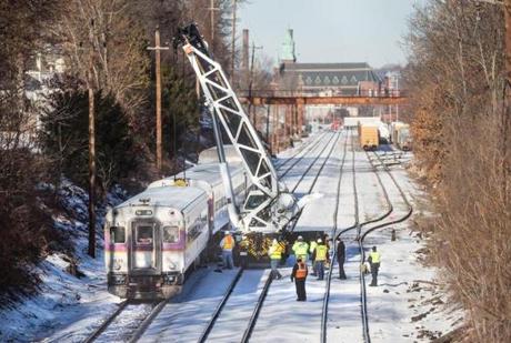 Workers used a specialized crane to get a derailed commuter rail train car back on the tracks Tuesday morning. 
