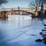 A runner crossed a bridge near a patch of ice along the Charles River Esplanade on Wednesday.