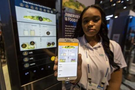 Enea Culverson of Samsung displayed an app that can interact with the refrigerator behind her. Among key features are cameras that take photos of items in the fridge, so shoppers can update their list of items.
