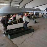 Contract workers loaded a Hellfire missile onto a US Air Force MQ-1B Predator unmanned aerial vehicle (UAV) at an air base in the Persian Gulf region. 