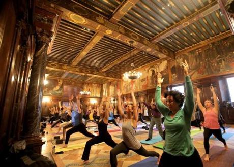 Esther Anastasia (front, in green), practiced yoga at the Boston Public Library?s historic Abbey room. 
