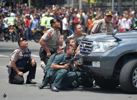 Indonesian police took position behind a vehicle as they pursued suspects after a series of blasts hit Jakarta.

