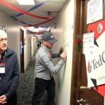 Organizer Ken Brolin looked at door decorations as volunteer Jerry Dunleavy, of Columbus, Ohio, signed a poster in the hallway at ?Camp Cruz?earlier this month.