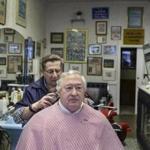 Joe Vaccarella, cuttting David Weselcouch?s hair, will miss his customers who work for GE, and their business.