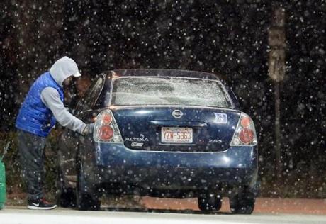 A man filled his car with gas in Durham, N.C., as snow began to fall before sunrise Friday. 
