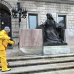Workers cleaned graffiti off the front of statues at the Boston Public Library.