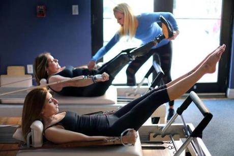 Marathon bombing survivors Sydney Corcoran (foreground) and her mother, Celeste, do pilates under the supervision of instructor Julie Erickson at the Endurance Pilates and Yoga Studio. 
