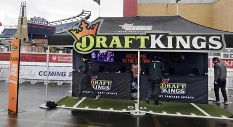 In this Oct. 25, 2015, photo, workers set up a DraftKings promotions tent in the parking lot of Gillette Stadium.
