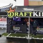 In this Oct. 25, 2015, photo, workers set up a DraftKings promotions tent in the parking lot of Gillette Stadium.