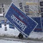 A worker walked with election signs in the snow in Manchester, N.H. 