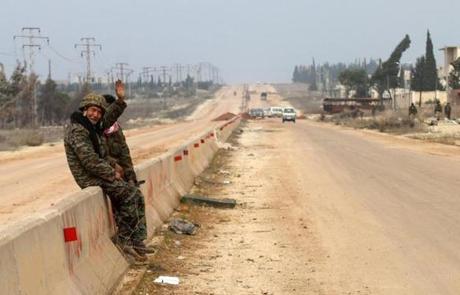 A member of the Syrian government forces waved as he sat on the road leading to Gaziantep on the outskirts of the village of Kiffin on Thursday.
