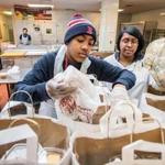 02/20/2015 JAMAICA PLAIN, MA Volunteer Larry Wilkins (cq) 14 (left) and prep cook Lakeisha Hall (cq) build bags for clients at Community Servings (cq) in Jamaica Plain. (Aram Boghosian for The Boston Globe)