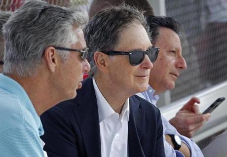 02/24/16: Fort Myers, FL: Left to right, Red Sox President of Baseball Operations Dave Dombrowski, Principal Owner John Henry, and Chariman Tom Werner were seated together in a dugout watching the action on one of the practice fields today. Spring Training for Red Sox players continued at Jet Blue South.(Globe Staff Photo/Jim Davis) section:sports topic:spring training

