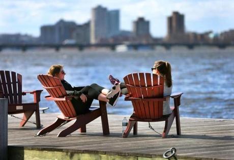 Suffolk University students Brenna McCoubrey (left) and Gina Gates lounged on a dock on the Charles River Esplanade after their classes. 
