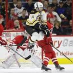 Boston Bruins' Brett Connolly (14) jumps to avoid the puck as Carolina Hurricanes' Jaccob Slavin, right, goalie Cam Ward and Joakim Nordstrom, left, of Sweden, watch during the second period of an NHL hockey game in Raleigh, N.C., Friday, Feb. 26, 2016. (AP Photo/Gerry Broome)