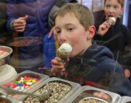 Kieran Feldman, 7, contemplated additional toppings as he took a bite of his cone at Dorchester?s Ice Creamsmith. 
