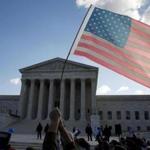 Protesters held an American flag in front of the Supreme Court Wednesday. The court will hear arguments in a major abortion case out of Texas. 