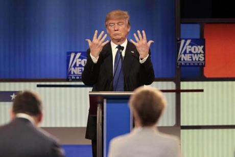 Republican U.S. presidential candidate Donald Trump shows off the size of his hands as Fox News Channel moderators Brett Baier (L) and Megyn Kelly (R) look on at the U.S. Republican presidential candidates debate in Detroit, Michigan, March 3, 2016. REUTERS/R

