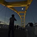 People watched a total solar eclipse from the Bay Bridge in Palu, Central Sulawesi, Indonesia, on Wednesday.