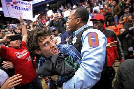 A police officer held a protester after a campaign rally for Donald Trump was canceled at the UIC Pavilion in Chicago on Friday.
