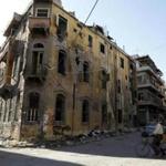 A man rides a bicycle near a building damaged during the Syrian conflict between government forces and rebels in Homs, Syria May 13, 2014. Picture taken May 13, 2014. REUTERS/Omar Sanadiki