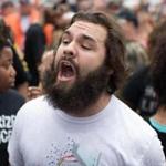 Thomas Dimassimo, here pictured shouting at pro-Confederate flag supporters in Georgia, was arrested after he had rushed the stage at a Trump campaign event.