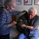 Ruth Bier helped her husband, Ghost Army veteran Bud Bier, don his Eisenhower jacket in their home in Dartmouth.