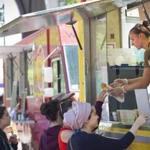 Catherine Aust,  who worked at the Bon Me food truck, served hungry patrons during lunchtime in 2014. 