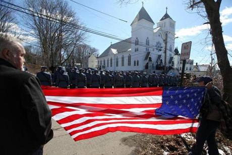 Residents watched and held a flag as Massachusetts State Troopers walked in a procession to the wake for Massachusetts State Trooper Thomas Clardy in Hudson. 
