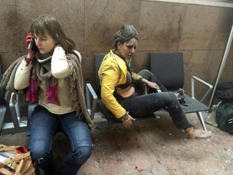 In this photo provided by Georgian Public Broadcaster and photographed by Ketevan Kardava, injured women are seen in Brussels Airport in Brussels, Belgium, after explosions were heard Tuesday, March 22, 2016. A developing situation left a number dead in explosions that ripped through the departure hall at Brussels airport Tuesday, police said. All flights were canceled, arriving planes were being diverted and Belgium's terror alert level was raised to maximum, officials said. (Ketevan Kardava/ Georgian Public Broadcaster via AP)
