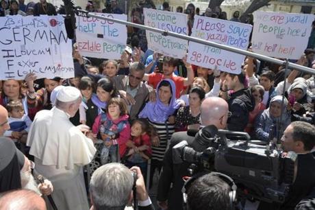 This handout picture released by the Vatican press office shows Pope Francis (R) meeting with migrants and refugees during a visit at Moria refugee camp near the port of Mytilene in the Greek island of Lesbos. Pope Francis on Saturday told despairing migrants trapped on the Greek island of Lesbos they were 