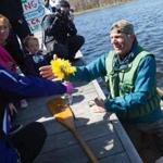  Boston, MA - 4/20/2016 - Denny Alsop receives flowers from third graders from Muddy Brook Elementary school as he comes ashore on the Charles River Esplanade after completing a one month canoe trip across the waters of the commonwealth in an effort to highlight needed cleanup of the Housatonic River in Boston, MA, April 20, 2016. (Keith Bedford/Globe Staff) 