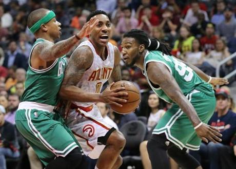 Atlanta Hawks' Jeff Teague drives through a double-team by Boston Celtics' Isaiah Thomas and Jae Crowder during the first half in Game 5 of a first-round NBA playoff basketball series Tuesday, April 26, 2016, in Atlanta. The Hawks won 110-83 and lead the series 3-2. (Curtis Compton/Atlanta Journal Constitution via AP)
