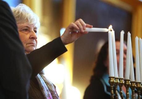 Holocaust survivor Eva Fleischmann Paddock lit the first of seven memorial candles at Faneuil Hall.
