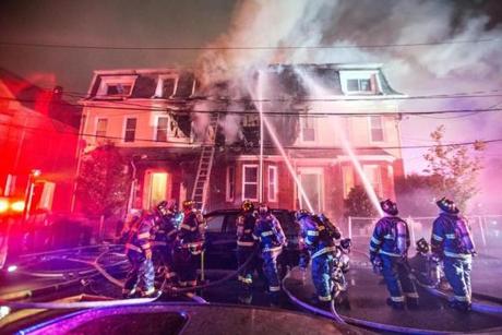 Firefighters battle a three-alarm fire on Rush Street in East Somerville.

