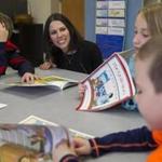 Southbridge state receiver Jessica Huizenga talked to West Street School first-grader Jayme Kenney (far right) about the book ?The Quilt Story? as classmates Dylan Ritchotte (left) and Eve Dziengeleski listened.