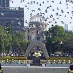 Doves fly over the Peace Memorial Park with a view of the gutted A-bomb dome at a ceremony in Hiroshima, Japan August 6, 2006. REUTERS/Issei Kato/File Photo