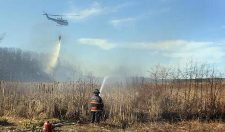 A helicopter dropped water on the fire that spread across 42 acres of marshland in Old Orchard Beach, Maine, in April.
