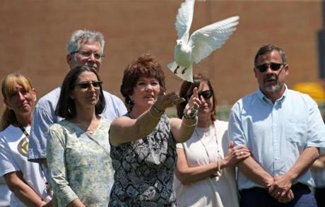 New Bedford, MA - 5/25/2016: The widow Rosemarie Heath releases a white dove at the Greater New Bedford Regional Vocational-Technical High School and Class of 2016 wishes to honor and pay tribute to our lost colleague, teacher, mentor and friend, Mr. George Heath. GNB Voc-Tech will hold a small ceremony celebrating Mr. Heath's life and many contributions here at the school with a few acknowledgments on Wednesday, May 25, 2016 at 1pm at the Jeffrey E. Riley Football Stadium on the campus of GNB Voc-Tech. (David L Ryan/Globe Staff Photo) SECTION: METRO TOPIC 26heathpic
