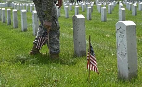 Members of the Old Guard place flags in front of every headstone at Arlington National Cemetery in Arlington, Va., Thursday, May 26, 2016. Soldiers were to place nearly a quarter of a million U.S. flags at the cemetery as part of a Memorial Day tradition. (AP Photo/Susan Walsh)
