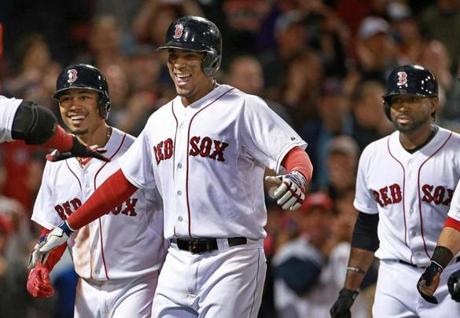 09/21/15: Boston, MA: The Red Sox Xander Bogaerts (second from left) is all smiles as he and the three teammates that scored ahead of him (left to right) Mookie Betts, Jackie Bradley Jr. and Dustin Pedroia head in the direction of a waiting David Ortiz following his bottom of the eighth inning grand slam that provided the winning runs in an eventual 8-7 victory over the Rays. The Boston Red Sox hosted the Tampa Bay Rays in a regular season MLB baseball game at Fenway Park. (Globe Staff Photo/Jim Davis) section:sports topic:Red Sox-Rays
