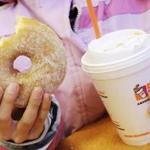 FILE - In this Thursday, Feb. 14, 2013, file photo, a girl has a doughnut and a beverage at a Dunkin' Donuts in New York. Dunkin' Brands reports financial earnings on Thursday, Feb. 4, 2016. (AP Photo/Mark Lennihan, File)