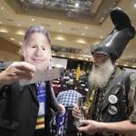 Vermin Supreme, right, a Libertarian Party presidential hopeful, hands out bumper stickers to a delegate wearing a Gary Johnson mask at the party's national convention in Orlando, Fla., May 29, 2016. The Libertarian Party on Sunday chose Gary Johnson as its presidential candidate, believing he can benefit from disappointment at the major partiesâ?? choices. (Phelan M. Ebenhack/The New York Times)