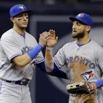 Toronto Blue Jays' Troy Tulowitzki, left, high fives Kevin Pillar after the Blue Jays defeated the Tampa Bay Rays 5-3 during a baseball game, Sunday, April 3, 2016, in St. Petersburg, Fla. (AP Photo/Chris O'Meara) 