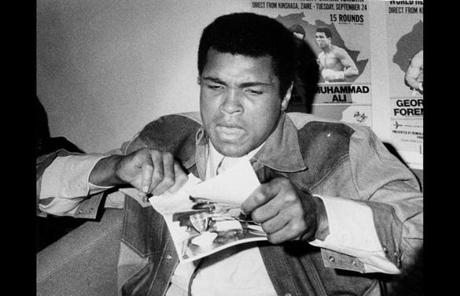 In an undated photo, Ali tore up a picture of George Foreman during an appearance at Logan Airport.
