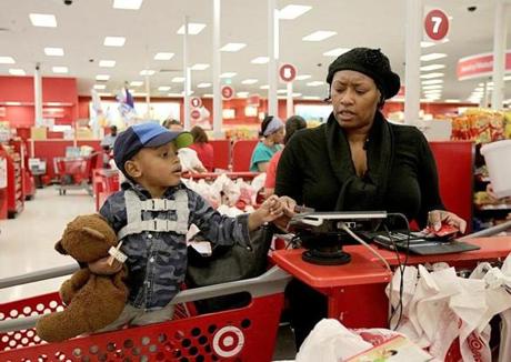 Colleen Michell, with her son Hanson, struggled with her chip card at a Target store in Dorchester. The cards represent a step up for security and a step down for efficiency.
