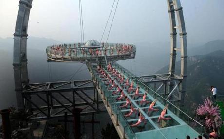Hundreds of yoga lovers practice yoga on the world?s largest glass and titanium saucer-shape sighting platform in in a scenic zone in Beijing, China, on June 20. (Lao Cai/EPA)
